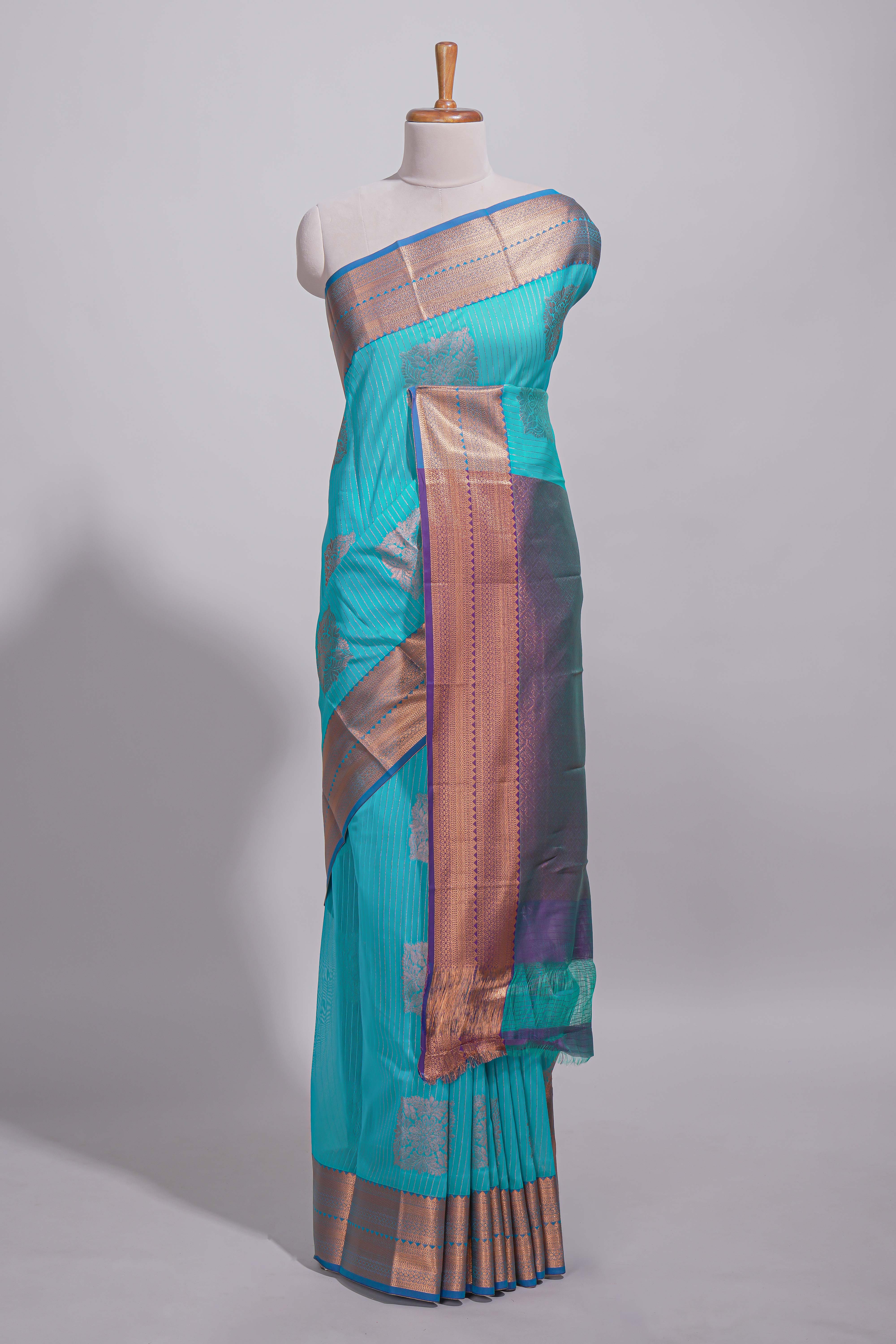 Blue tussar saree with gold zari floral buttas teal zari border and woven zari pallu with contrast blouse piece