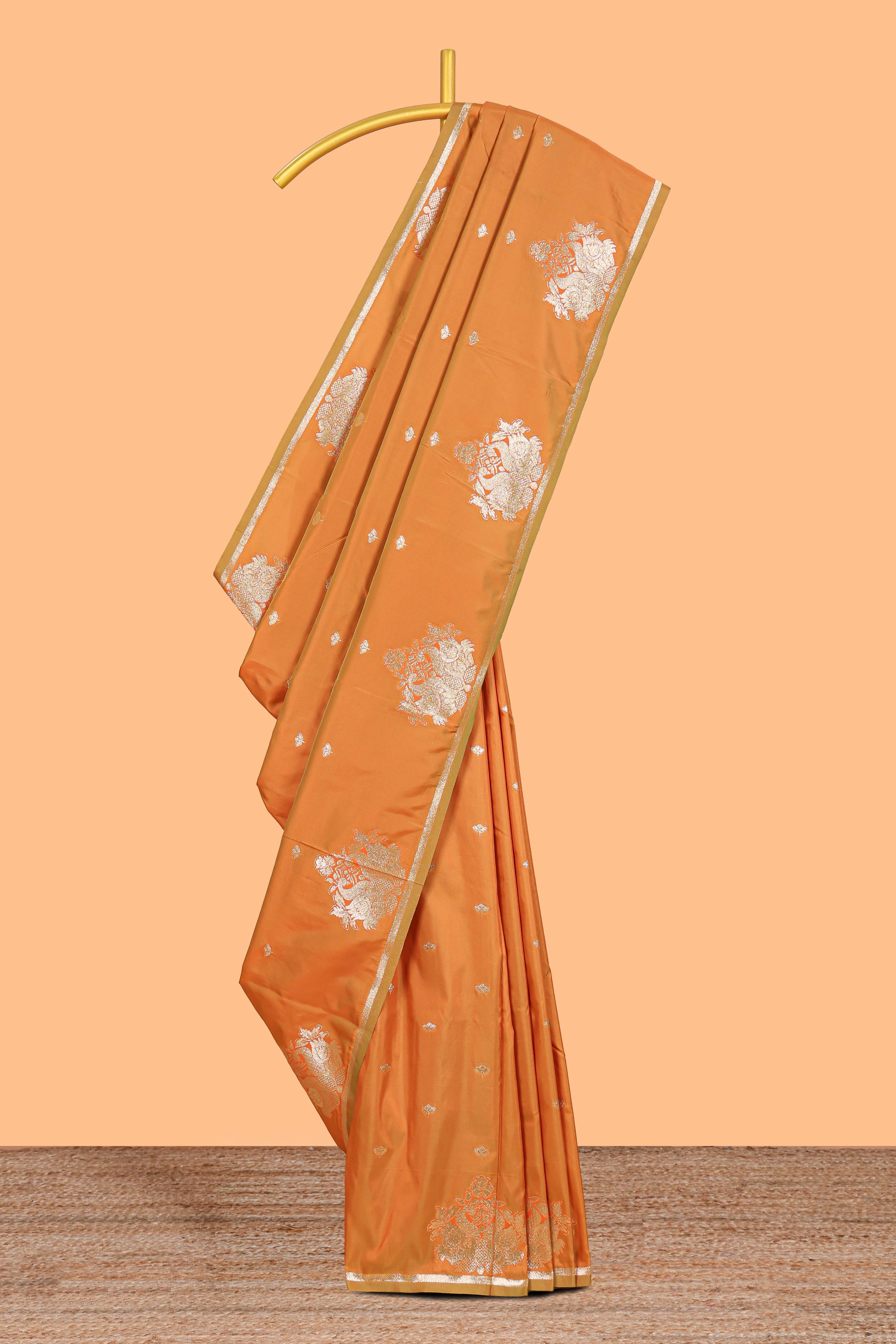 Rust Orange colour Semi soft silk with gold zari floral motifs border with peacock motifs and matching blouse